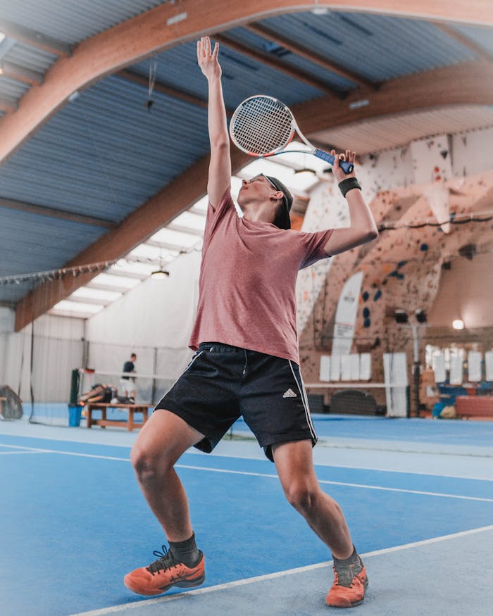 pexels-photo-3818835 A focused athlete performing a powerful tennis serve indoors in Austria.